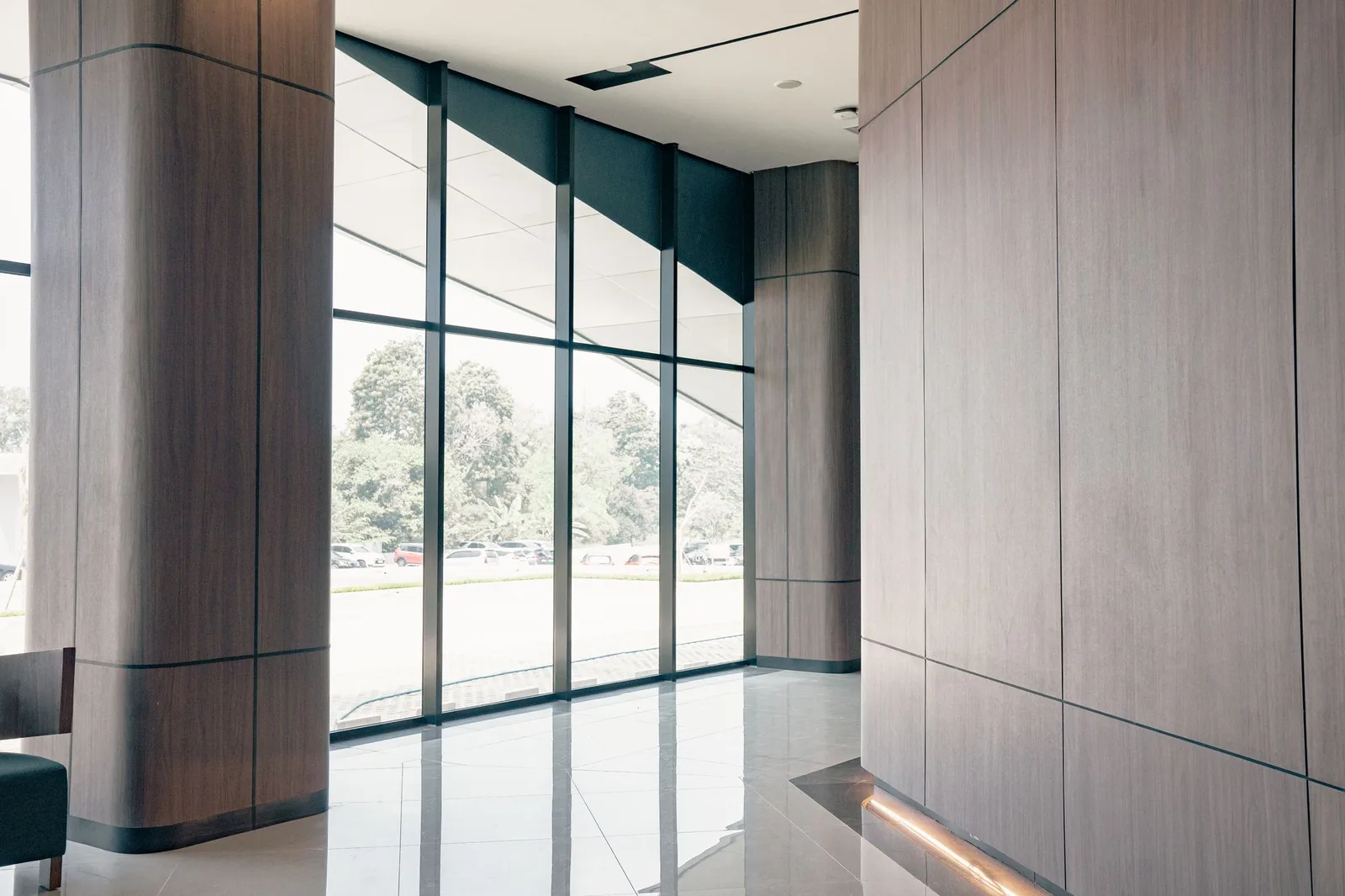 Commercial lobby with floor-to-ceiling glazing and wood-veneer wall panels